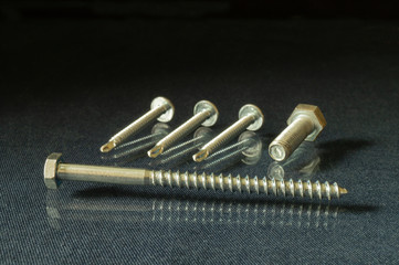 Bolt with thread by nut and puck on table with reflection