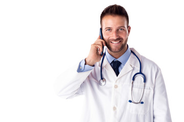 Happy doctor standing at isolated white background while having a call