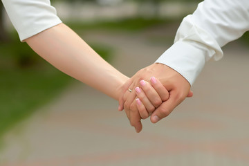Happy couple holding hands. wedding. close up.