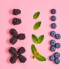 Blueberry, blackberry layout. Fresh blueberry, berries mix on pink. Red raspberry, mint creative composition. Colorful minimal concept, top view.