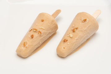 Malai kulfi traditional Indian ice scream or Qulfi, Rajasthani home made ready to eat frozen dairy dessert. rajwari or rajwadi sweet kesar badam pista ice cream candy