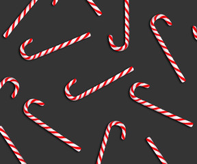 Pattern of Christmas candy canes on dark grey background, top view