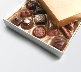 Caja de bombones de chocolate obre fondo blanco, vista cenital. Box of chocolates on a white background, overhead view.