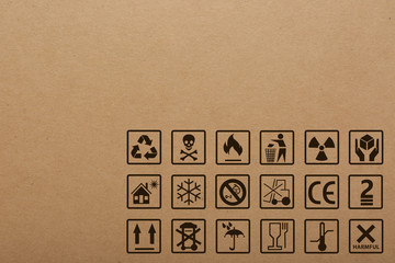 Cardboard box with packaging symbols as background, closeup