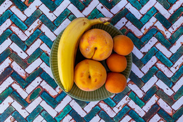 still life with natural and fresh seasonal fruits on a green plate