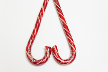 Fototapeta premium Сandy cane on white background, top view flat lay. Sweet sucker, lollipop, candy, isolated minimal concept above decoration, food background