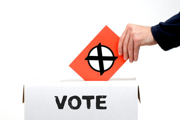 Hand schmeißt Stimmzettel in Wahlurne mit Aufschrift Vote