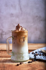 glass of dalgona coffee with chocolate and on a rustic background