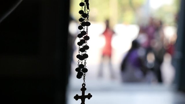 Silhouette of a rosary necklace with blurred background   