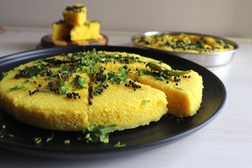 Indian traditional Dal dhokla. Khaman dhokla is a famous dish of Gujarat. Made using rice, healthy mix lentils and pulses, along with spices. garnished with coriander & fried chilies. Copy space.