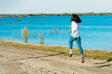 Female is jumping and flying to successful. Hurry up fly to development goal on nature background. Back view, run to purpose, success.