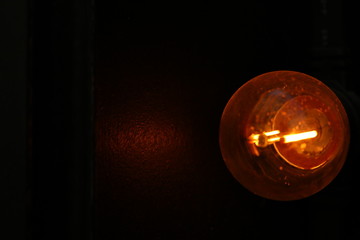 Ampoule jaune orang&eacute;e dans le noir 