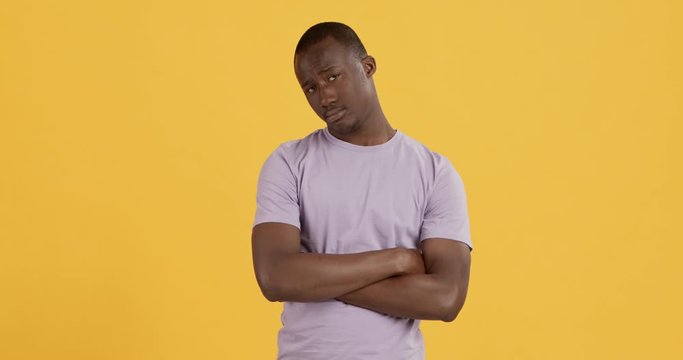 Offended african american guy folding arms and pouting lips to camera