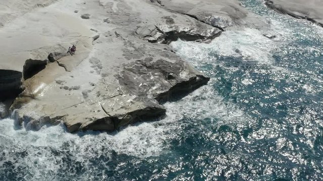Aerial View of Sarakiniko Lunar Volcanic Beach with Waves crashing into rocks in Milos, Greece