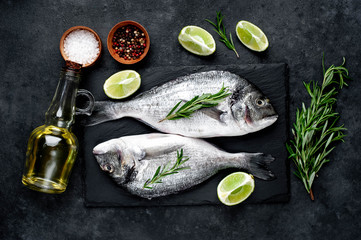Raw dorado fish with ingredients on stone background