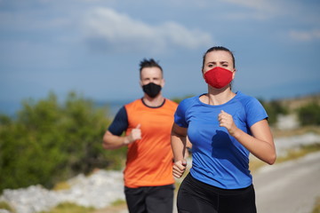 Naklejka premium couple running in nature wearing mask