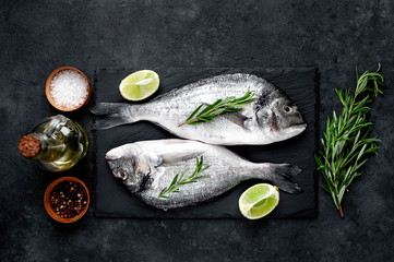 Raw dorado fish with ingredients on stone background