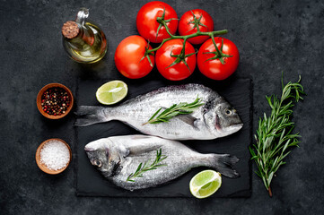 Raw dorado fish with ingredients on stone background