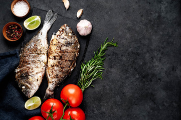 grilled dorado fish with ingredients on stone background with copy space for your text