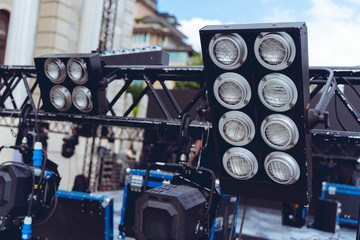 Naklejka na ściany i meble Installation of professional sound, light, video and stage equipment for a concert. Stage lighting equipment is clamped on a truss for lifting. Flight cases with cables..