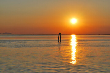 
sunset on the Venetian lagoon with sun reflection on the water