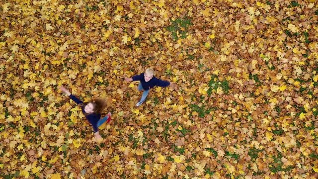 Happy Children Have Fun in Autumn Prak. Children Throw Yellow Fallen Leaves and Spin. Happy childhood concept.