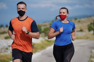 couple running in nature wearing mask