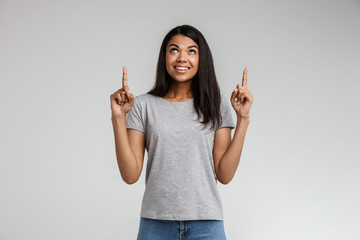 Smiling young african woman pointing at copy space