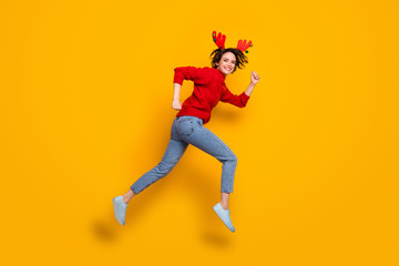 Fototapeta na wymiar Full size profile photo of pretty funny lady jump high up rushing newyear sale shopping center wear headband x-mas horns red knitted sweater jeans shoes isolated yellow color background
