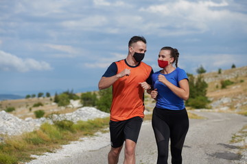 couple running in nature wearing mask