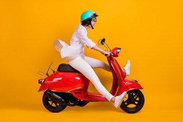 Full length profile side photo of excited surprised girl in helmet goggles drive scooter enjoy...