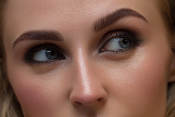 Closeup female eyes with bright make-up, great shapes brows, extreme long eyelashes. Celebrate makeup, luxury eyeshadows. Macro of beautiful eye. Good vision