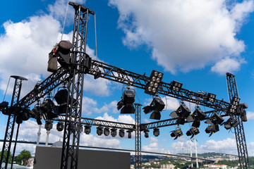 Installation of professional sound, light, led panel, video and stage equipment for a concert. Stage lighting equipment is clamped on a truss for lifting. Flight cases with cables.. - obrazy, fototapety, plakaty