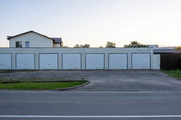 Fototapeta na wymiar garage row at sunset with white automatic doors