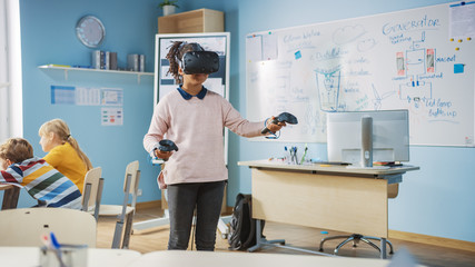 Elementary School Computer Science Class: Cute Girl Wearing Augmented Reality Headset and Using...