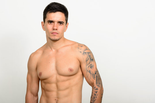 Portrait of handsome muscular shirtless man against white background