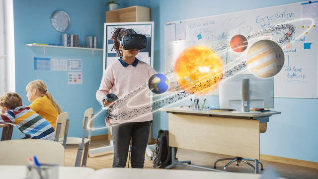 Cute Girl Wearing Augmented Reality Headset and Using Controllers Interacts with 3D Solar System. Futuristic School Science Class for Children Learning in STEM Programs. VFX, Special Effects Render