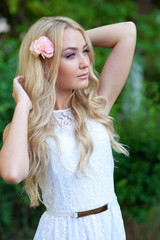Naklejka premium Beautiful young woman with flower. Blonde. Hair care. Summer