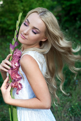Beautiful young woman with flower wreath and long hair. Blonde. Hair care. Summer. Bride