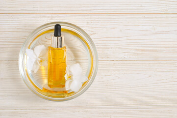 Natural cosmetic oil with phalaenopsis orchid flowers beautiful close-up flat lay composition on the white wooden