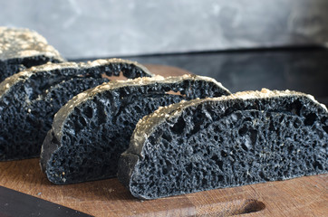 Italian black ciabatta bread sliced on a board