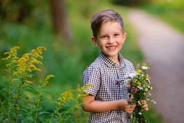 Smiling boy with a flowers bouquet