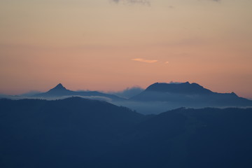 beautiful sunset on the mountains with orange sky and view to the alps