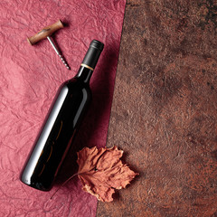 A bottle of red wine on an old rough background.