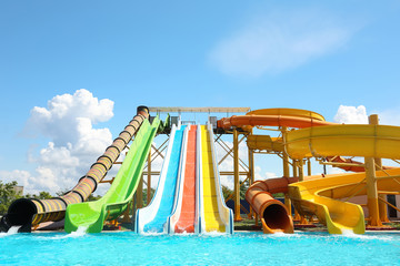 Fototapeta na wymiar Different colorful slides in water park on sunny day