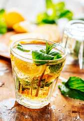 Closeup of mojito drink glass and  ingredients on vintage wooden table.