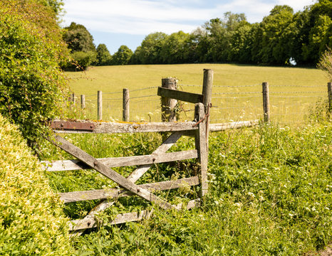 Old wooden stile at the entrance to a field. Rural English country scene.