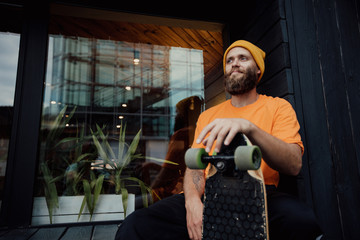 Handsome young stylish hipster guy with beard with a skateboard © San4ezz007