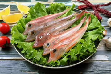 pesce gallinella di mare cruda in piatto con insalata verde