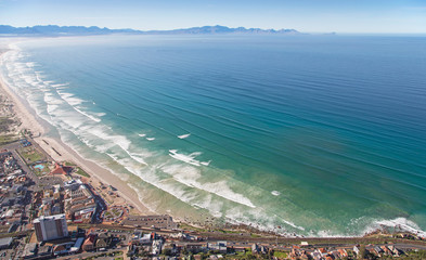 Cape Town, Western Cape / South Africa - 06/30/2020: Aerial photo of surfers and waves at Muizenberg Beach